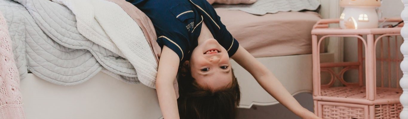 Klein meisje dat een donkerblauwe pyjama draagt en ze is gelukkig